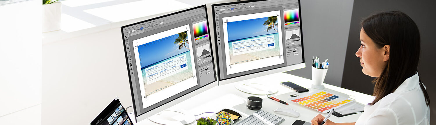A female graphic designer working on multiple screens and managing colors and photographs.