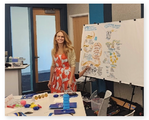 Kara Lehnhardt smiling at the camera while presenting at UMKC