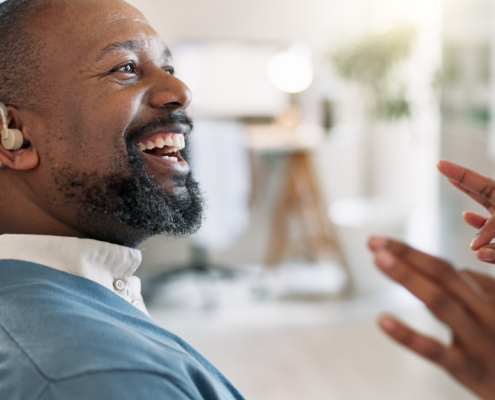 man with hearing aid looking at partner doing asl