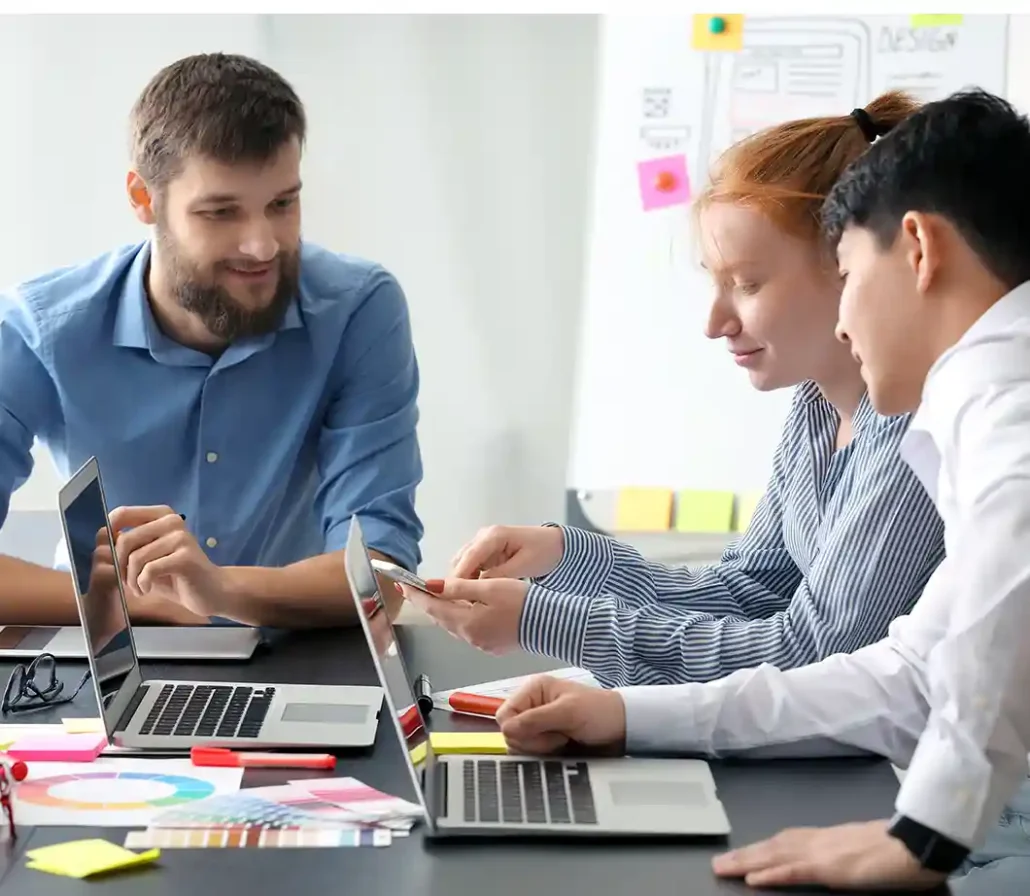People sitting around a table on their computers