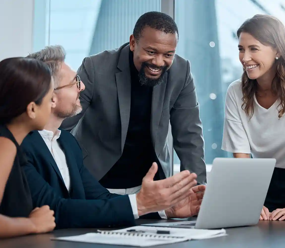 A group of professional collaborate around a computer.